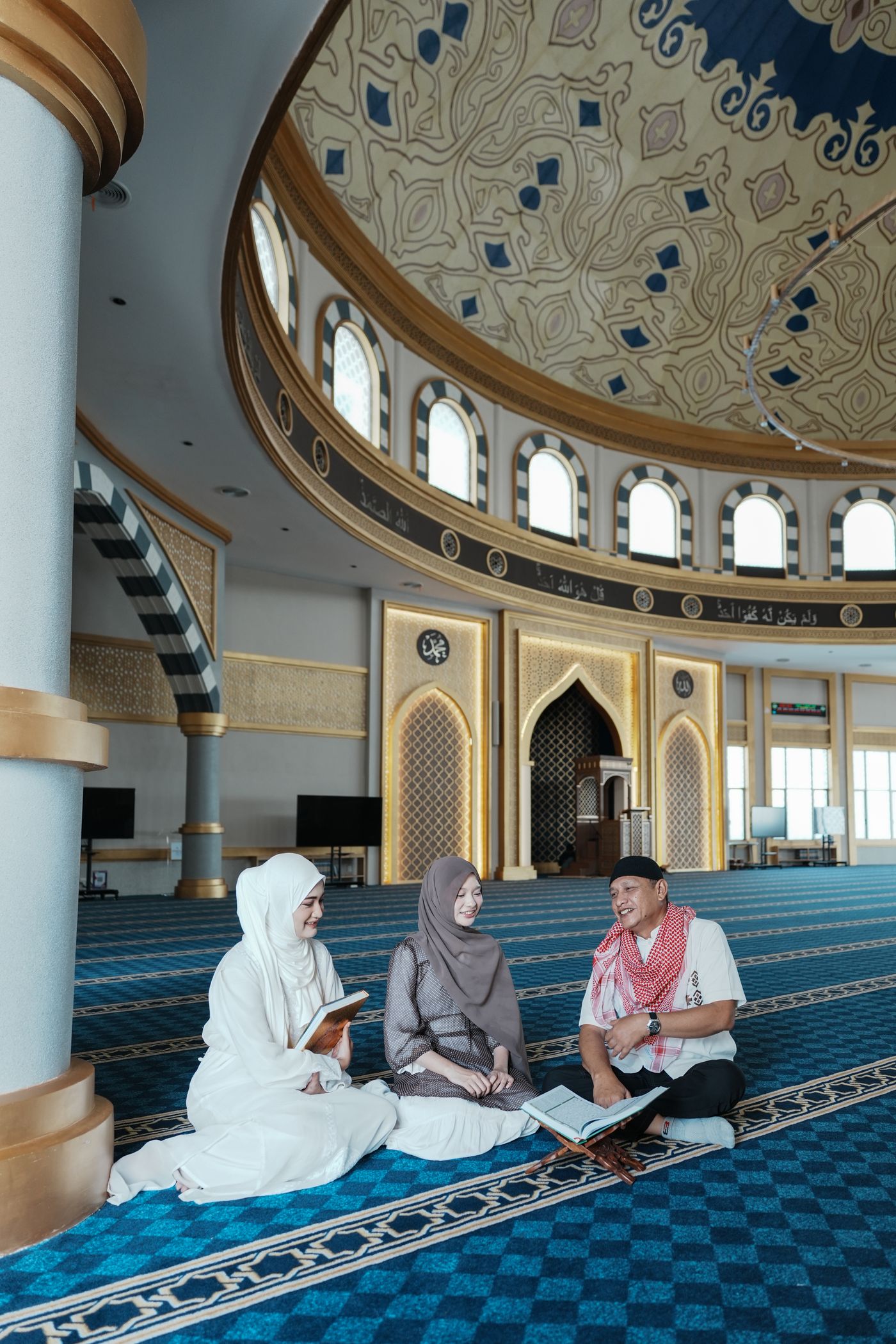 Keluarga Muslim belajar Al-Quran di masjid bernuansa emas
